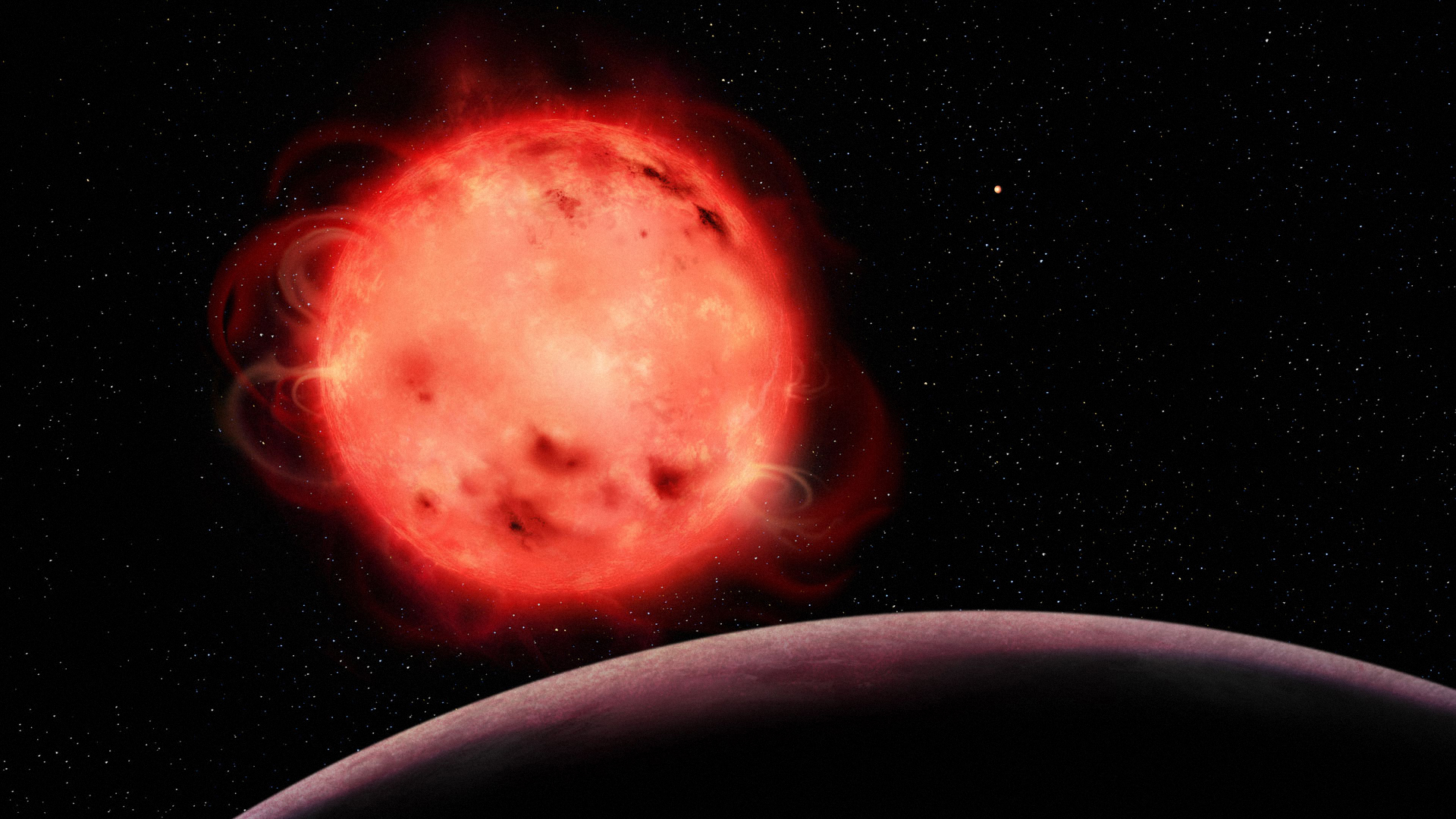 This artistic representation of the TRAPPIST-1 red dwarf star showcases its very active nature. The star appears to have many stellar spots (colder regions of its surface, similar to sunspots) and flares. The exoplanet TRAPPIST-1 b, the closest planet to the system’s central star, can be seen in the foreground with no apparent atmosphere. The exoplanet TRAPPIST-1 g, one of the planets in the system’s habitable zone, can be seen in the background to the right of the star. The TRAPPIST-1 system contains seven Earth-sized exoplanets. (Credit: Benoît Gougeon, Université de Montréal)